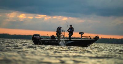 Small fishing boat alone in the water on sunset.Motor boat