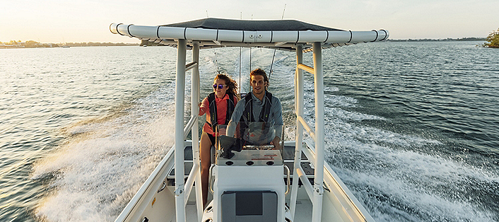 Man and woman at the helm of a center console boat
