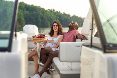 2025-SDX-270-Outboard-SDO270-lifestyle-couple-cockpit-table-07463