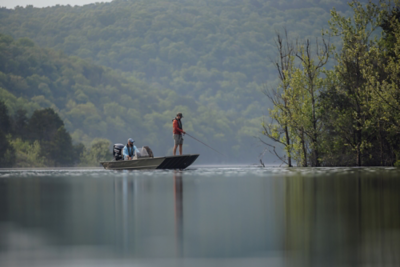 Two people fishing off a Lowe boat