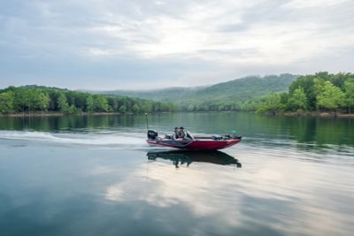 Two men driving a Lowe Mod-V fishing boat, starboard view, boat underway.
