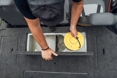 Angler pulling a bait bucket out of the livewell water on the Lowe Stinger 195 Bass. 