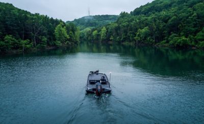 Fisherman Driving Lowe Stinger 198 Aluminum Bass Boat on Lake, Stern View