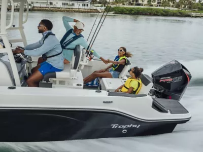 Man Bayliner Trophy Fishing Boat with Three Family Members, Starboard View, Boat Underway