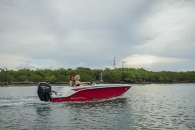 Man Driving Bayliner Deck Boat, Women Riding at Bow and Stern, Starboard View, Boat Underway