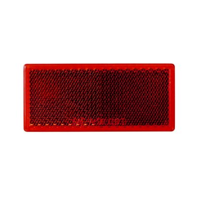 Red stick-on rectangle reflector with adhesive backing, designed for visibility and safety enhancements, featured on packaging.