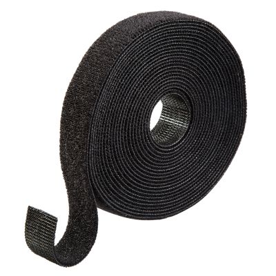 Black hook and loop fastener roll coiled neatly against a white background, highlighting texture and material.