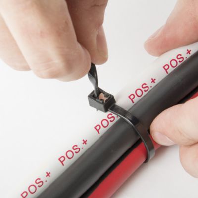 Self-cutting black cable ties securing red and black cables, showcasing ease of use and effectiveness.