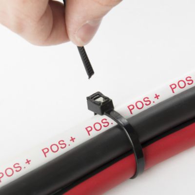 Self-Cutting Cable Tie in action, securing black and red cables with a UV black finish, demonstrating effective bundling.