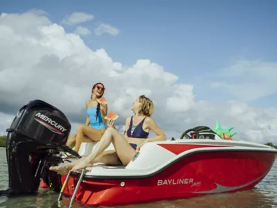 Two Women Sitting on Back of Anchored Bayliner M15, Port-Side View