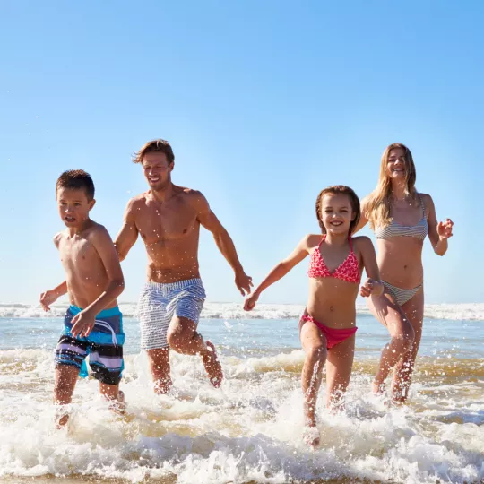 FAMILY RUNNING ON BEACH