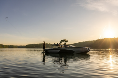 people on a heyday wakeboat at sunset