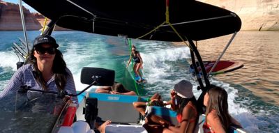 friends on a heyday wake boat towing a wakeboarder