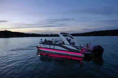 Harris Grand Mariner cruising at night with pink lights showing.