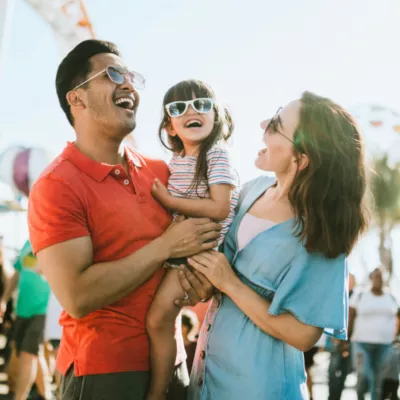 family smiling at a park