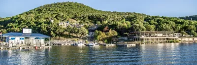 view of lake travis docks with green mountain in the background