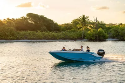 family on a blue M17 deck boat at sunset