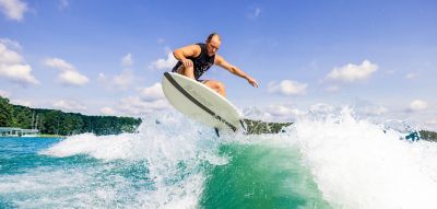 Wakeboarder up in the air behind a Heyday Wake boat