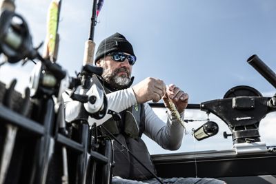 Fisherman in boat holding fishing lure