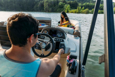 Mother and Daughter Sitting at the Front of a Lowe Pontoon Boat, Father Driving, Boat Underway