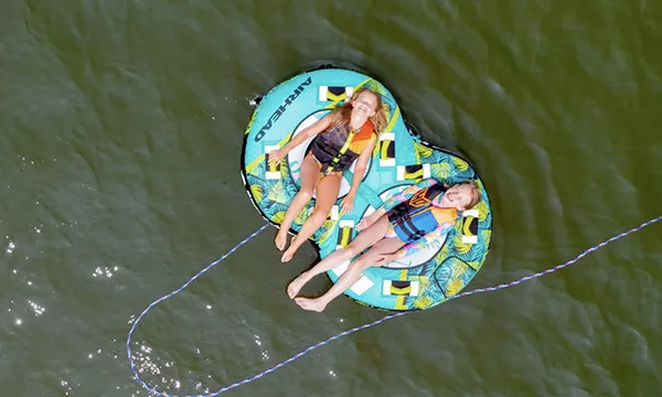 two girls floating on a tube