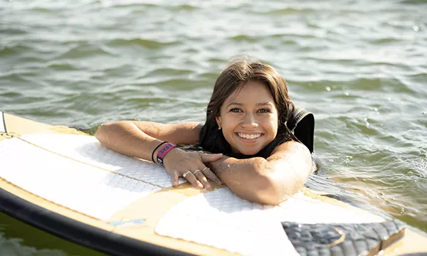 woman smiling on surfboard