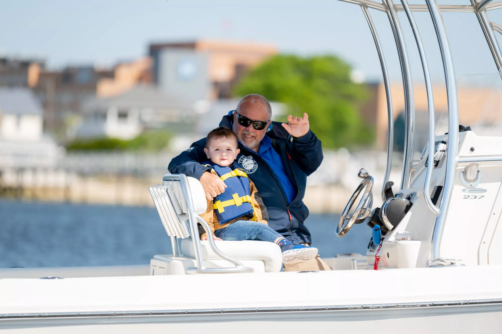 dad and son waving on boat in new gretna