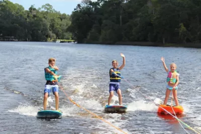 kids waving while waterskiing