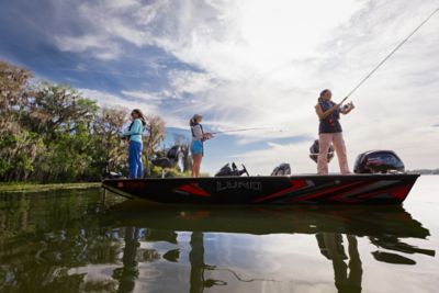 Mom and 2 kids on a paddleboard enjoying their day beside a boat.