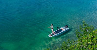 Small fishing boat skiff with outboard motor and seats anchored