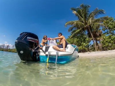 Man and Woman on Deck of Anchored Bayliner Boat with Mercury Outboard Engine, Palm Tree in Background