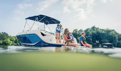 family sitting on the back of a D22i deck boat