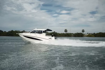 Man Standing on Bow at Bayliner Trophy Center Console Fishing Boat Reeling in Fish