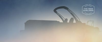Silhouette of a Harris Sunliner Pontoon boat set against a gradient blue sky.