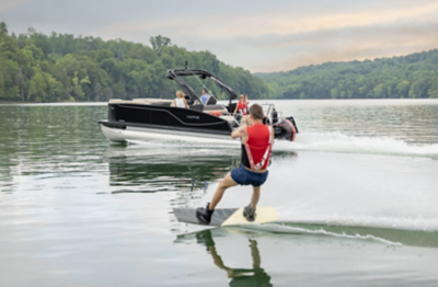 Family aboard a Harris Sunliner 250 Sport running across the water.