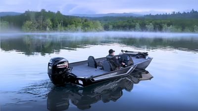 Man driving a Lowe Boats Skorpion 17 over the water with mist and trees in the background.