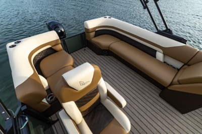 Tan and white Lowe pontoon boat interior with cushioned bench seating and a ribbed Trek deck floor, viewed from above over calm blue water. 