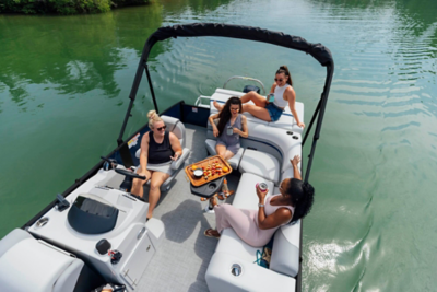 Group of ladies sitting on a Lowe pontoon boat with drinks and snacks.