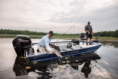 Fisherman in boat holding fishing lure