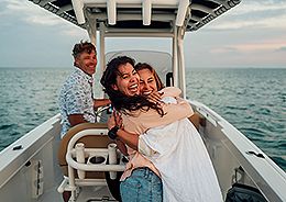 Two women hugging tightly on a boat, enjoying the peacefulness of the ocean.