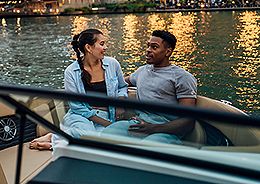 A couple enjoying a serene boat ride on the water, surrounded by calmness and tranquility.