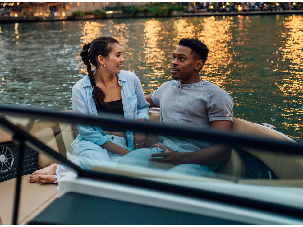 A couple enjoying a serene boat ride on the water, surrounded by calmness and tranquility.