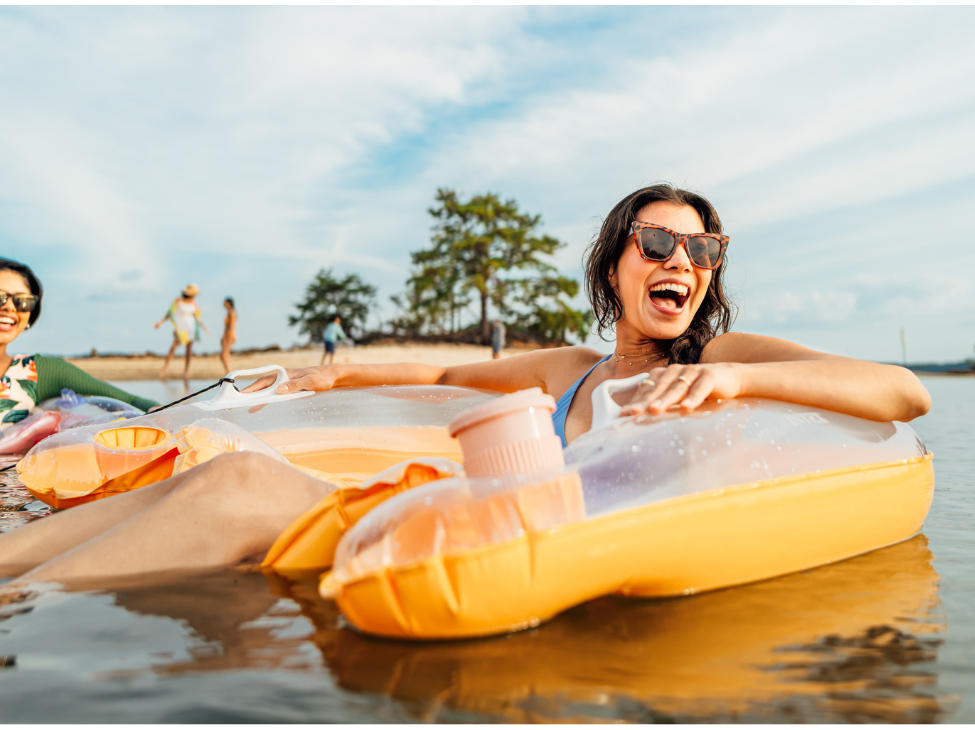 Two women on inflatable rafts floating in the water.